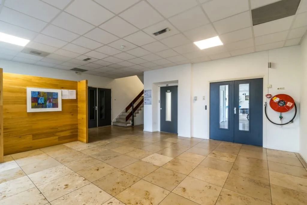 Entreehal van een gebouw aan de Jan van Eycklaan met lift, trap, dubbele deuren en brandslanghaspel.